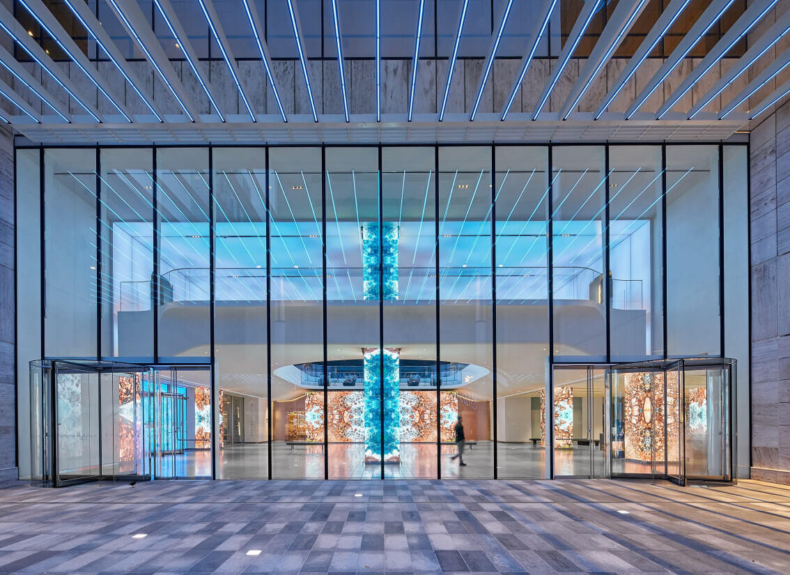 Front lobby of glass building featuring visual elements produced by Electrosonic.