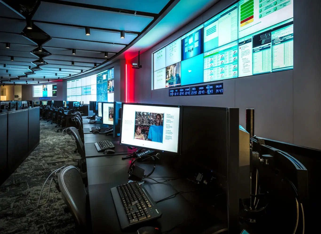  A dynamic control room features multiple large-format displays and an expansive video wall showcasing real-time data in a high-tech environment.