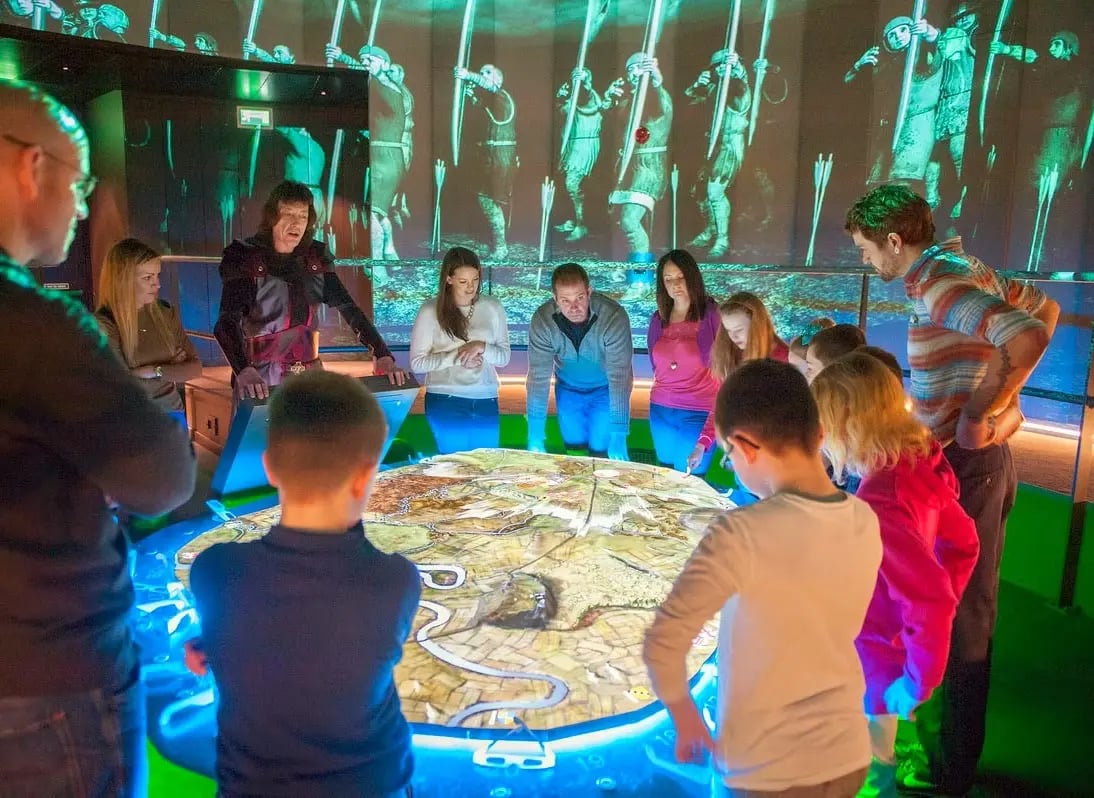 An immersive themed attraction uses projection mapping and synchronized lighting to create a cinematic storytelling environment.