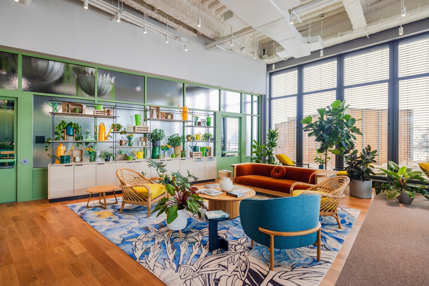 A sitting room with chairs and a wall surrounded by plants 
