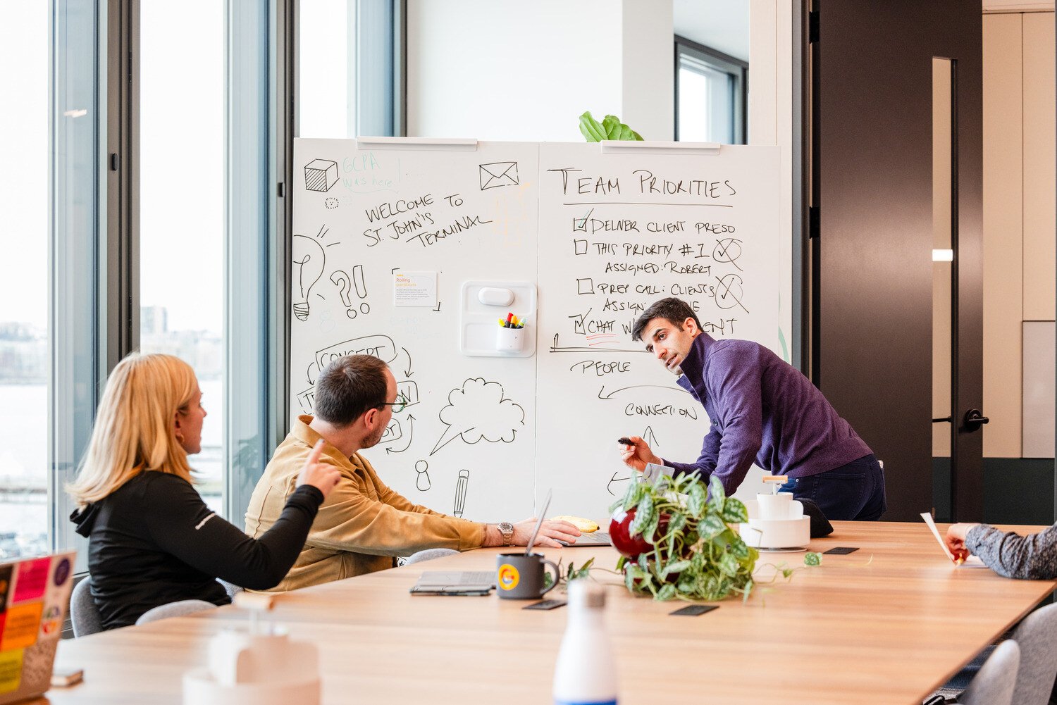 Three people thinking and drawing on a whiteboard 