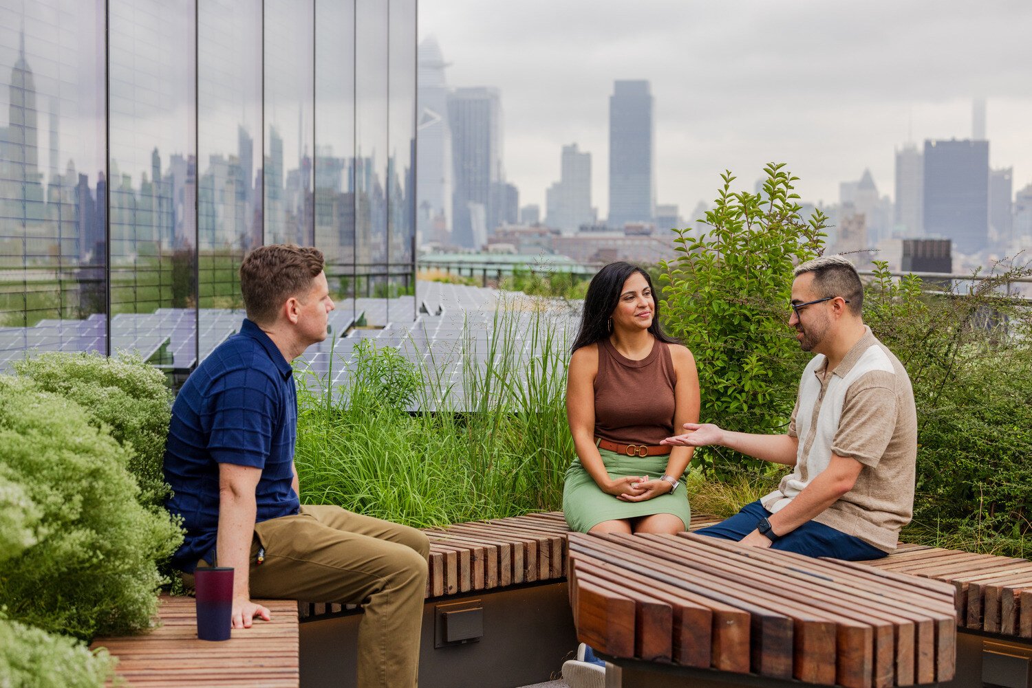 Three people sitting down and talking outside 