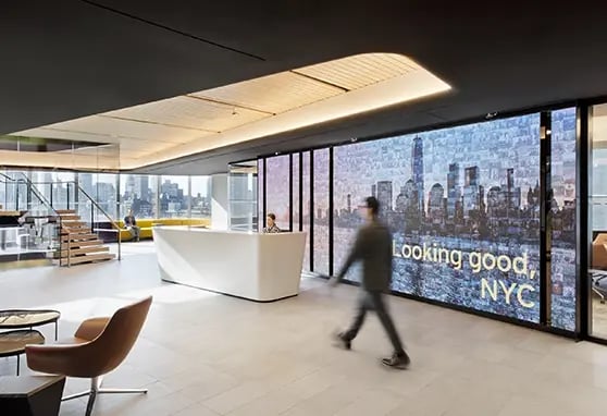 A branded digital video wall in a corporate lobby shares company milestones, live data and multimedia content to enhance employee and guest experiences.