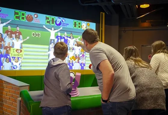 A father and his son playing games together at the Mascot Hall of Fame in Indiana.