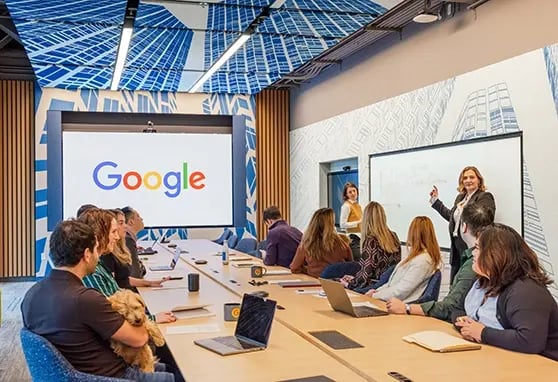 A group of Google employees sitting around a conference room during a meeting.