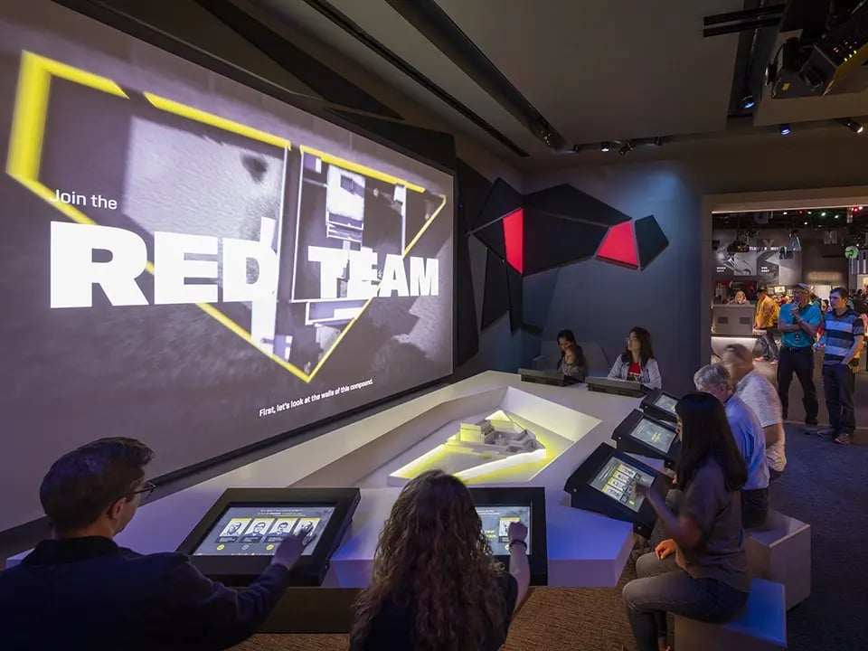 A group of visitors to the International Spy Museum engaged in an interactive experience.