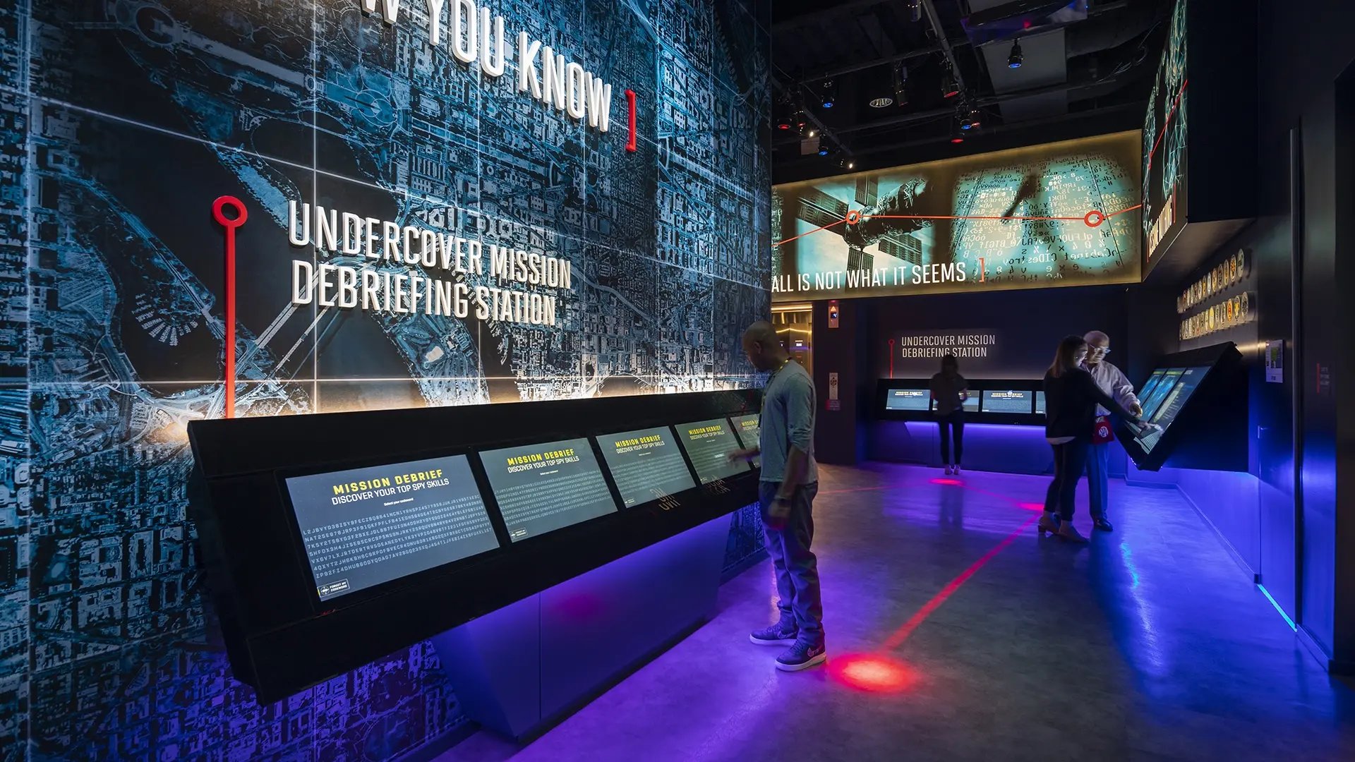 A group of visitors to the International Spy Museum interacting with touchscreens to complete their journey at the Museum.