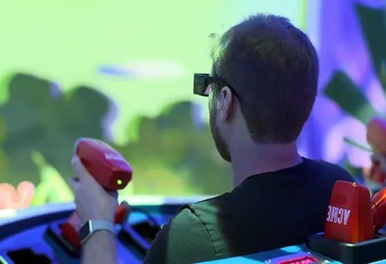 A guest firing a lidar ray at screens within the Ani Mayhem dark ride experience at Warner Bros. World Abu Dhabi.
