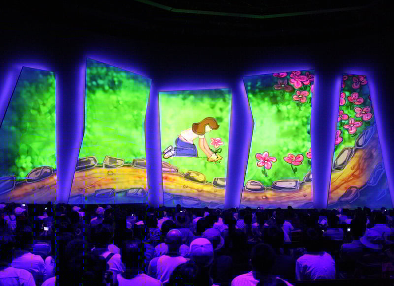A large audience watches an immersive animated show projected onto multiple irregularly shaped vertical LED Walls.