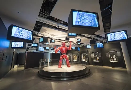 A large robot surrounded by LCD displays with the worlds largest museum complex.