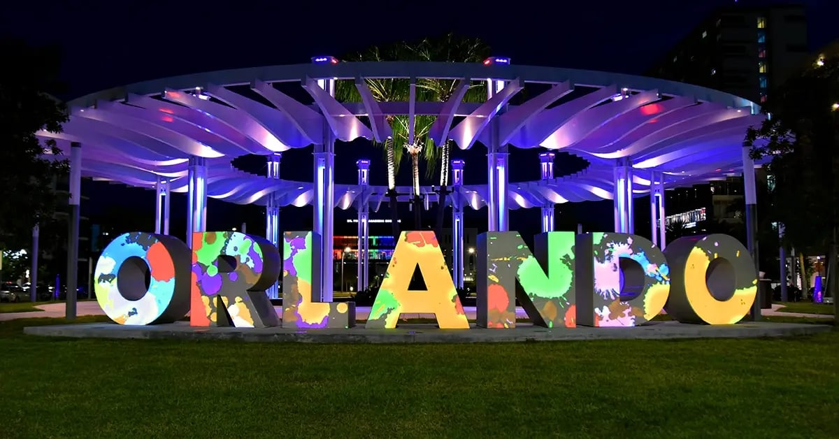 A large sign spelling Orlando is illuminated with colorful projection mapping that brings each letter to life with dynamic patterns and effects.