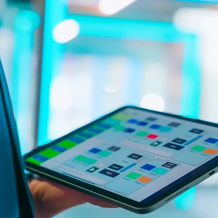 A man using an iPad to control the content being shown at their experience center.