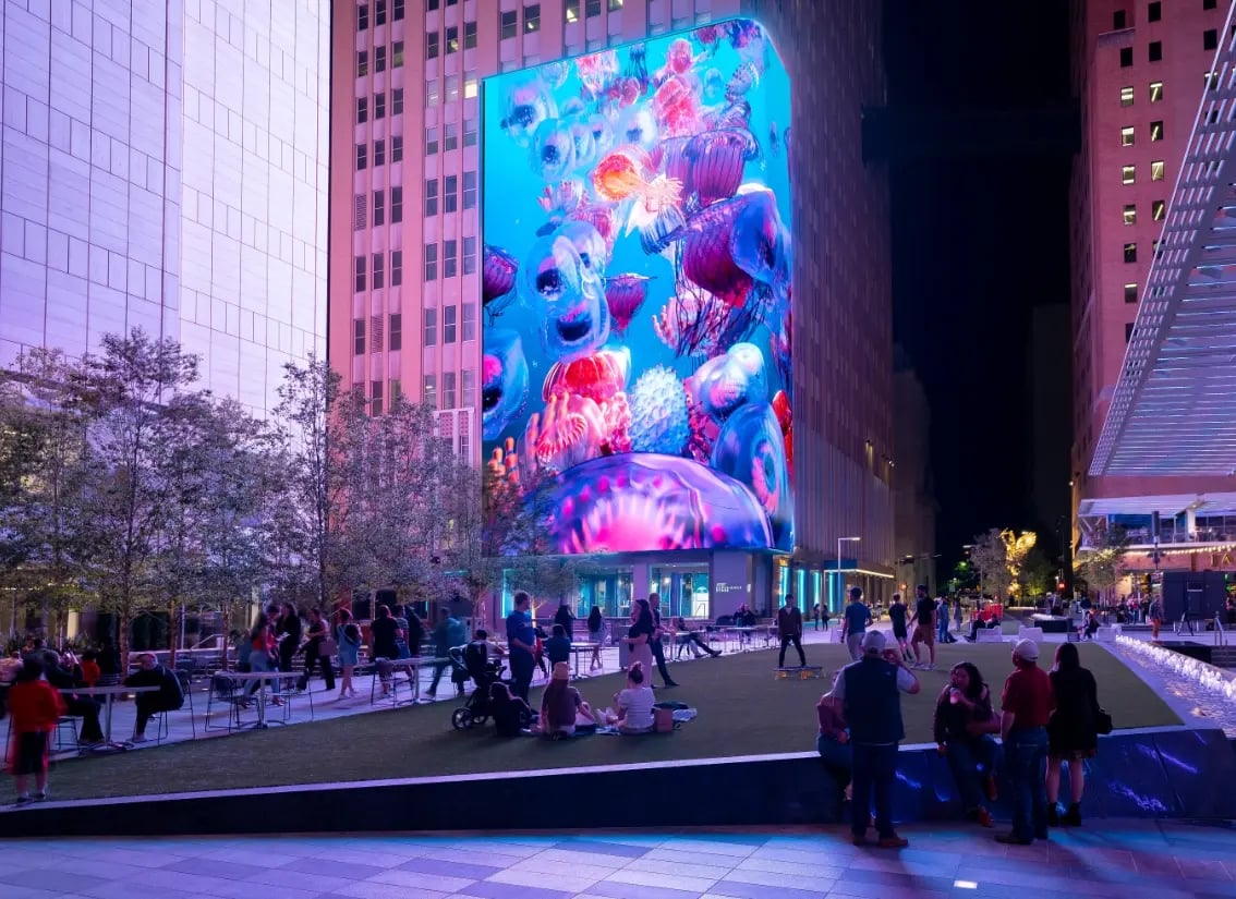 A massive wight story video wall towering over a downtown plaza.-1