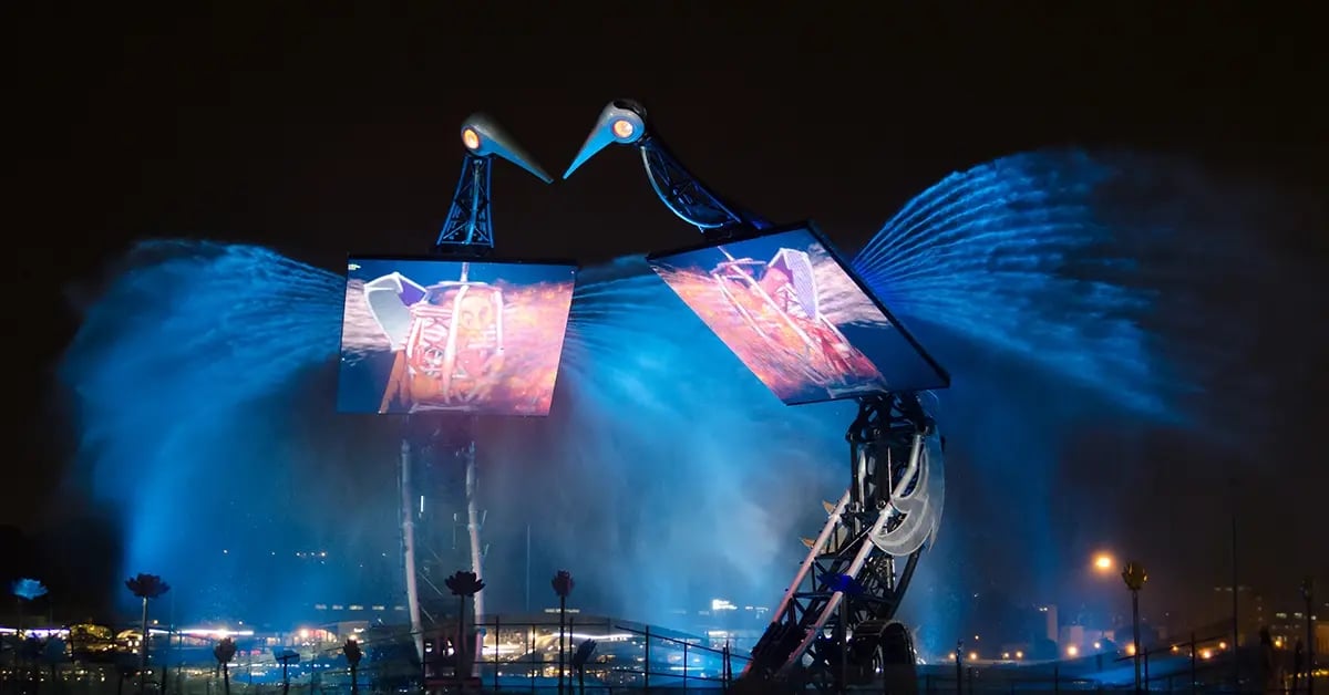 A nighttime shot of the Crane Dance show in Singapore, featuring animatronic cranes, water effects and synchronized LED visuals as part of a large-scale performance.