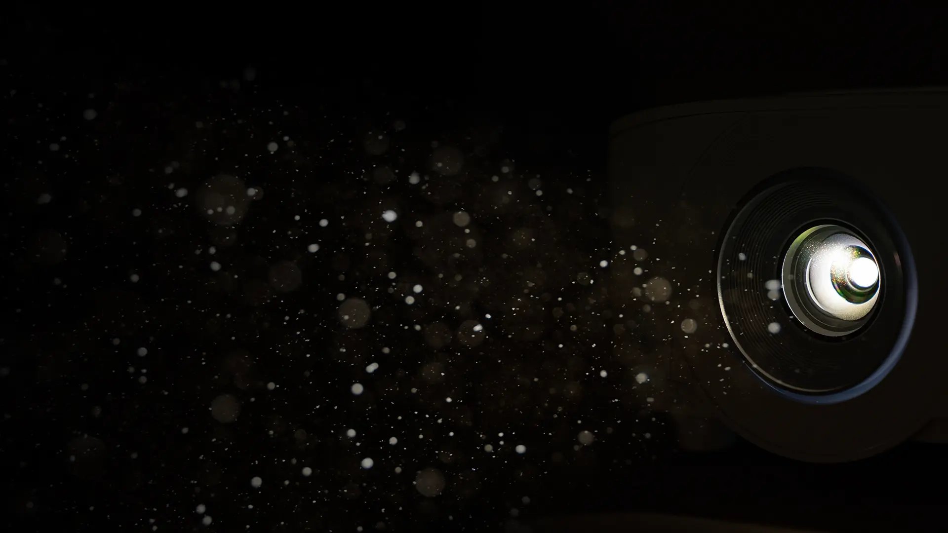 A projector emitting light into a darkened space.