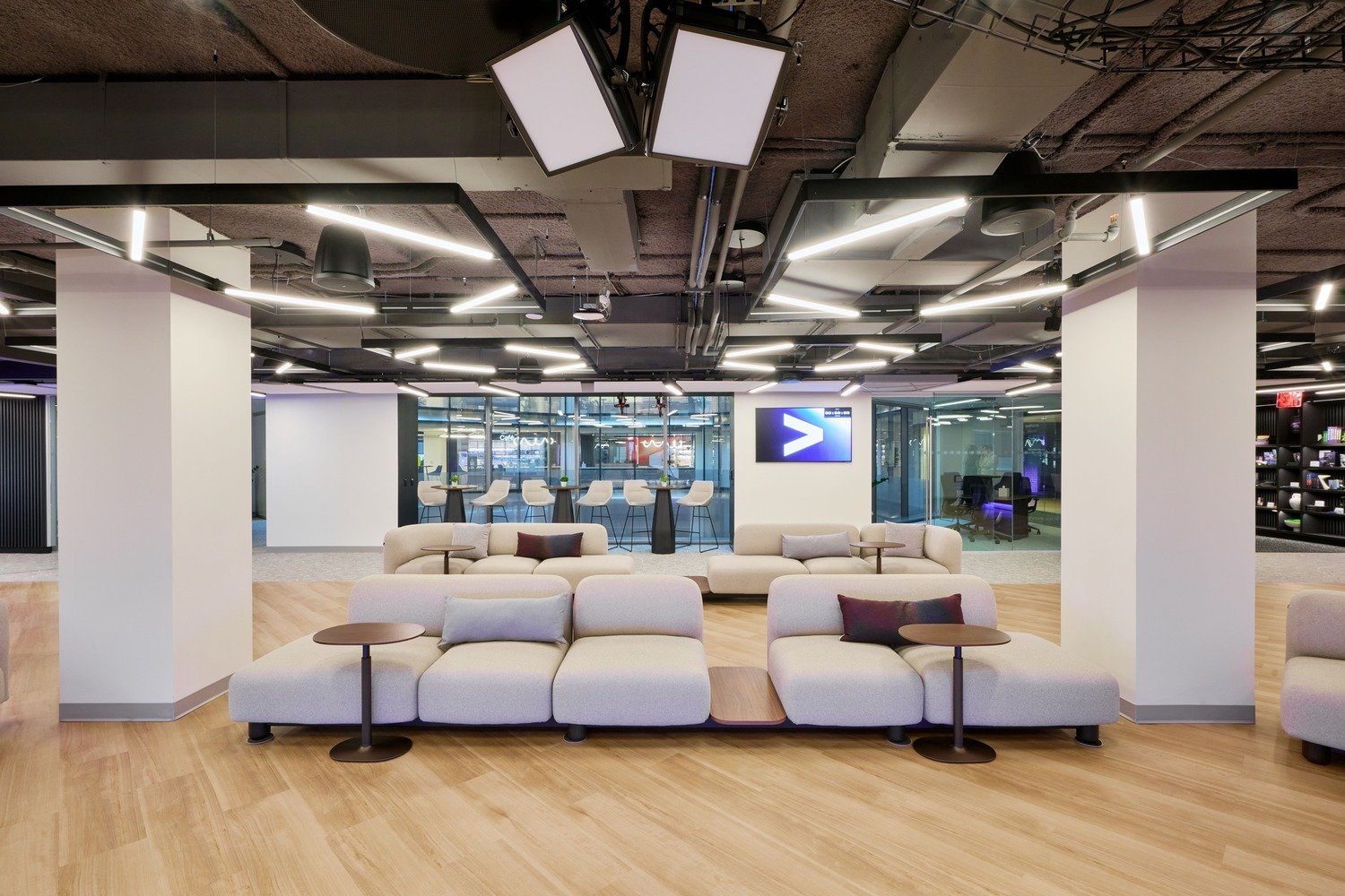 A ted-talk style room with couches and tables in the middle.