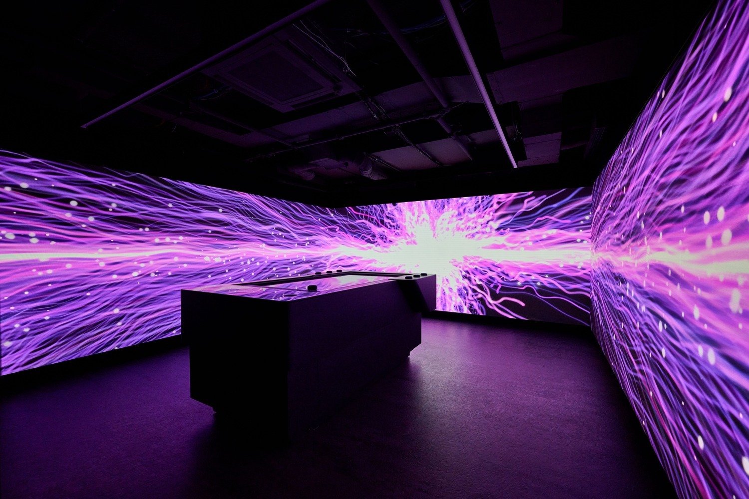 A meeting room with an interactive touch table and LED walls lining the room..