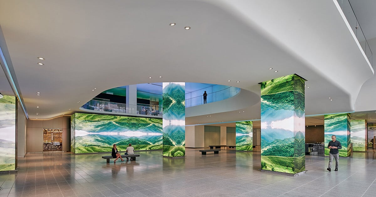 AT&T lobby space featuring a stunning digital transformation of architectural elements—columns and walls become immersive canvases showcasing vibrant, natural landscapes. The integration of LED panels wraps the environment in dynamic visuals, creating a serene yet technologically sophisticated atmosphere that blurs the line between built environment and digital art.