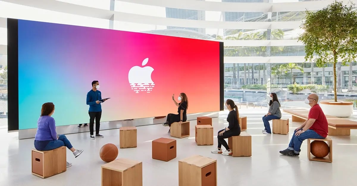 An Apple retail store interior features a massive LED video wall at the back of the space, used to display immersive branding, product visuals and promotional content.