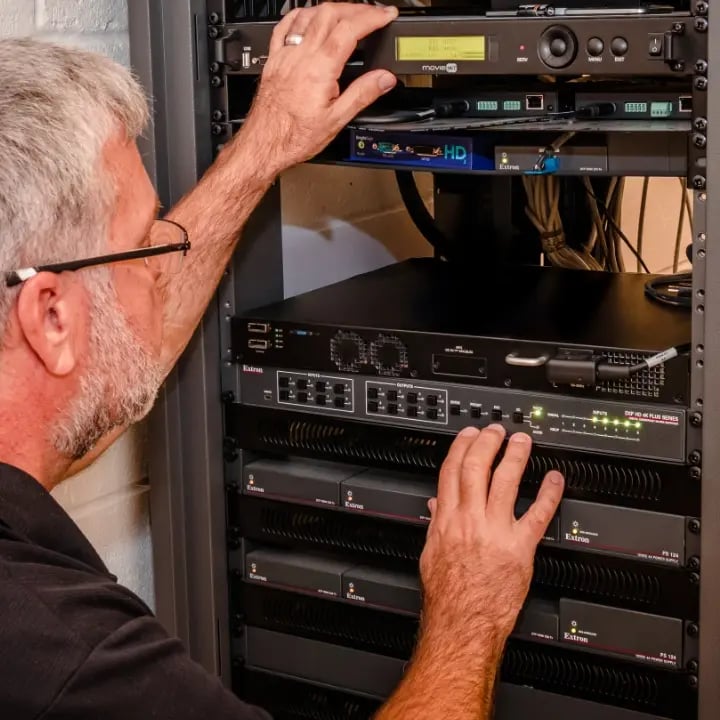 An Electrosonic AV technician configuring a rack with equipment.