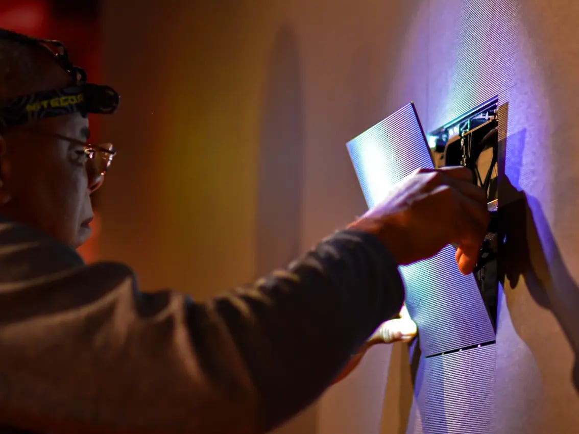 An Electrosonic employee installs an LED tile as part of a high-resolution display solution.