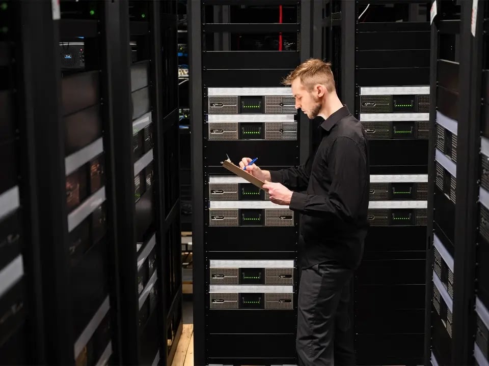 An Electrosonic technician inspects rack-mounted AV equipment to ensure optimal functionality.