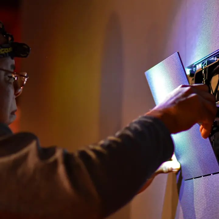 An Electrosonic technician installing LED tiles within a large LED wall.