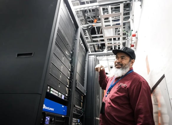 An Electrosonic technician smiling while completing the commissioning of an AV system on site.