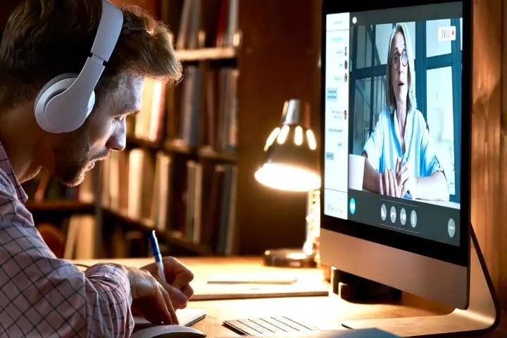 An IT professional being coached virtually by an Electrosonic service professional.