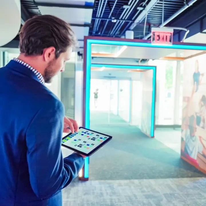 An employee using a tablet to monitor their audiovisual (AV) systems performance.
