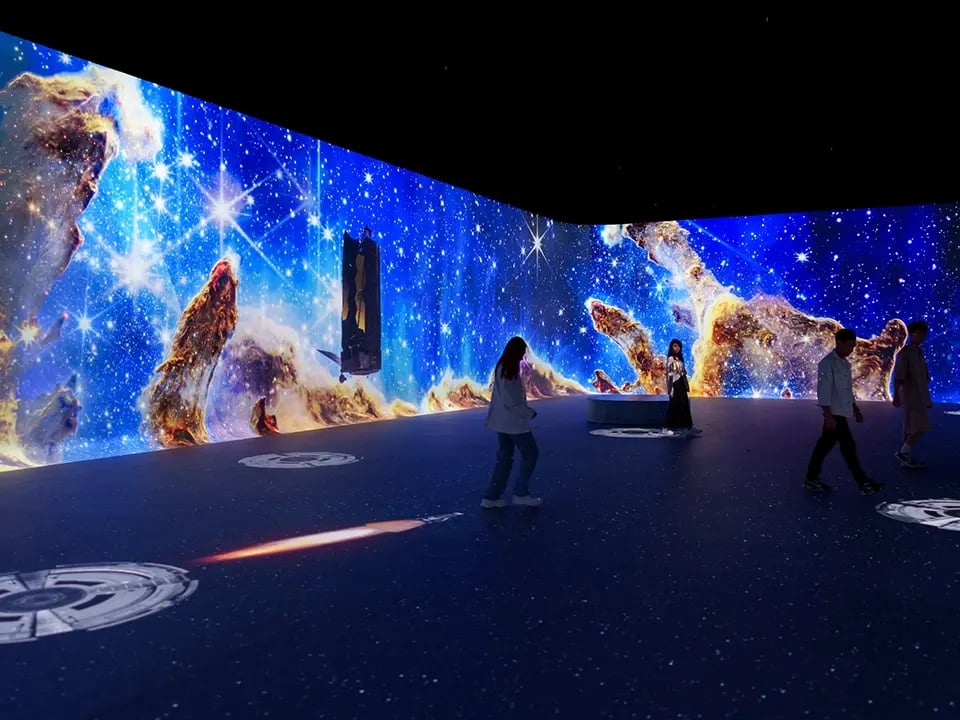 An immersive room where projection illuminates the walls with vibrant content.