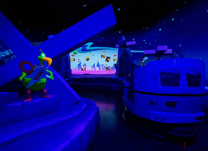 Dark ride carts moving through Ani-Mayhem at Warner Bros. World.