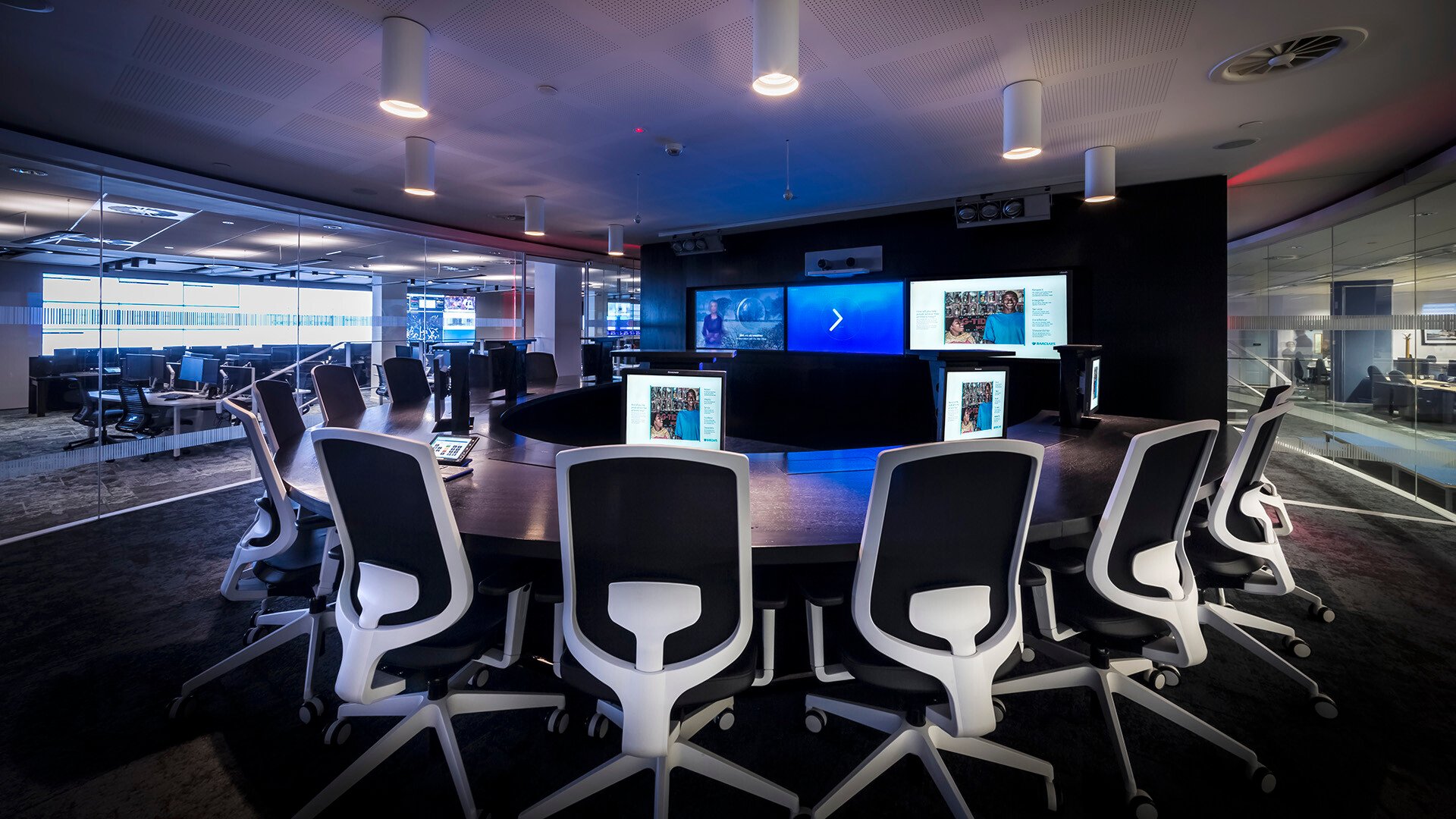Large meeting room with multiple monitors and modern furniture at the heart of a Barclay's control room.