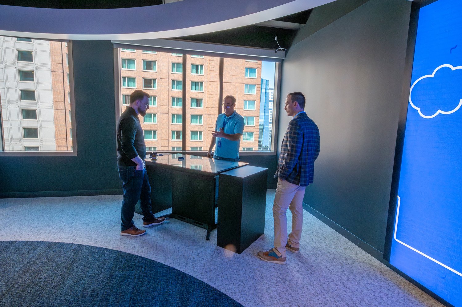 Three men talking around a touch table.