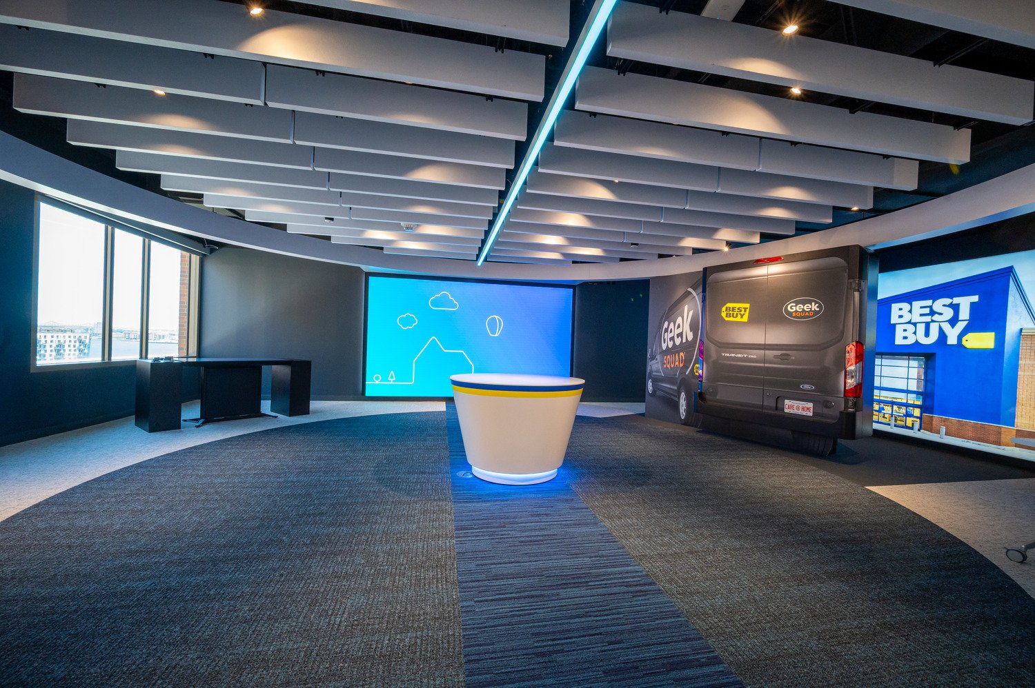 The main room with display in center, geek squad van in the right corner and window on the left side. 