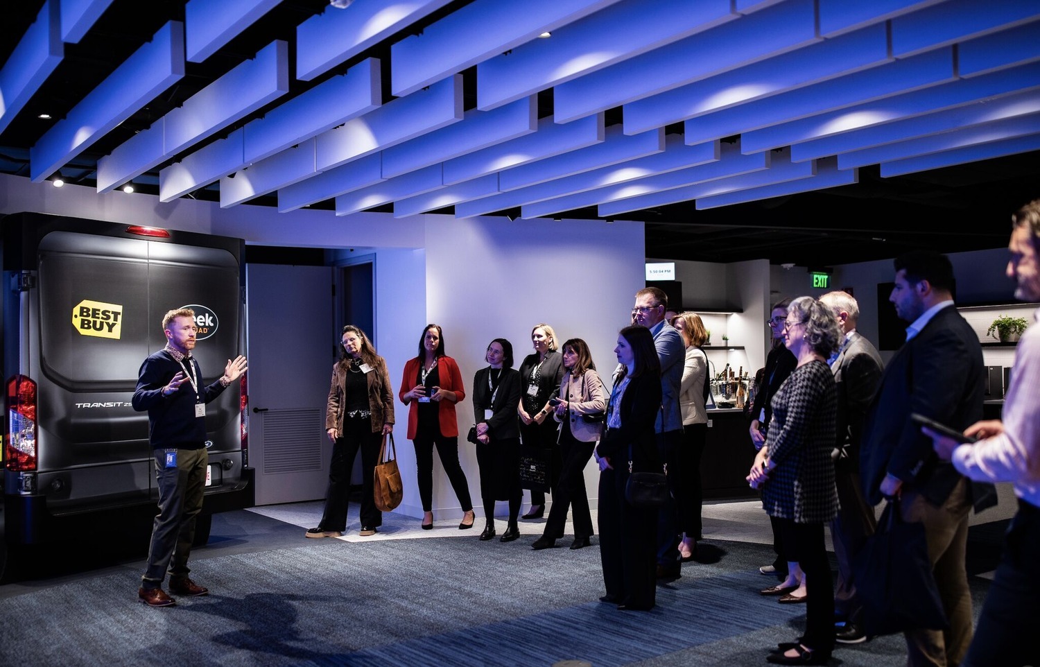 Group of people circled around a man talking