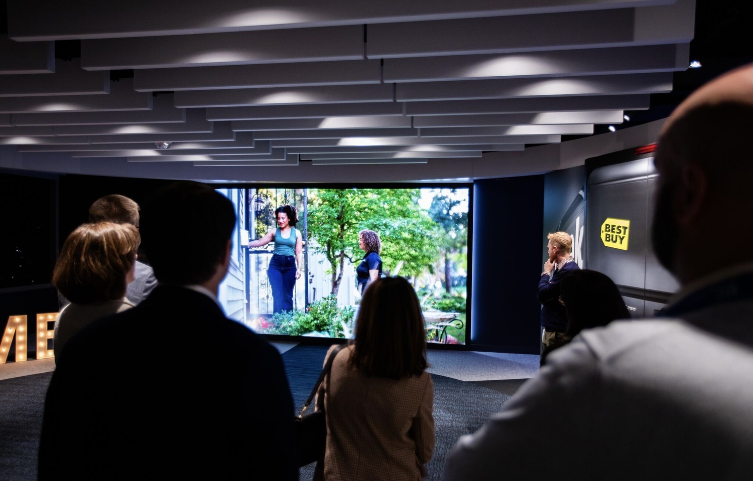 A group of people looking at a display learn about Best Buy Health benefits. 
