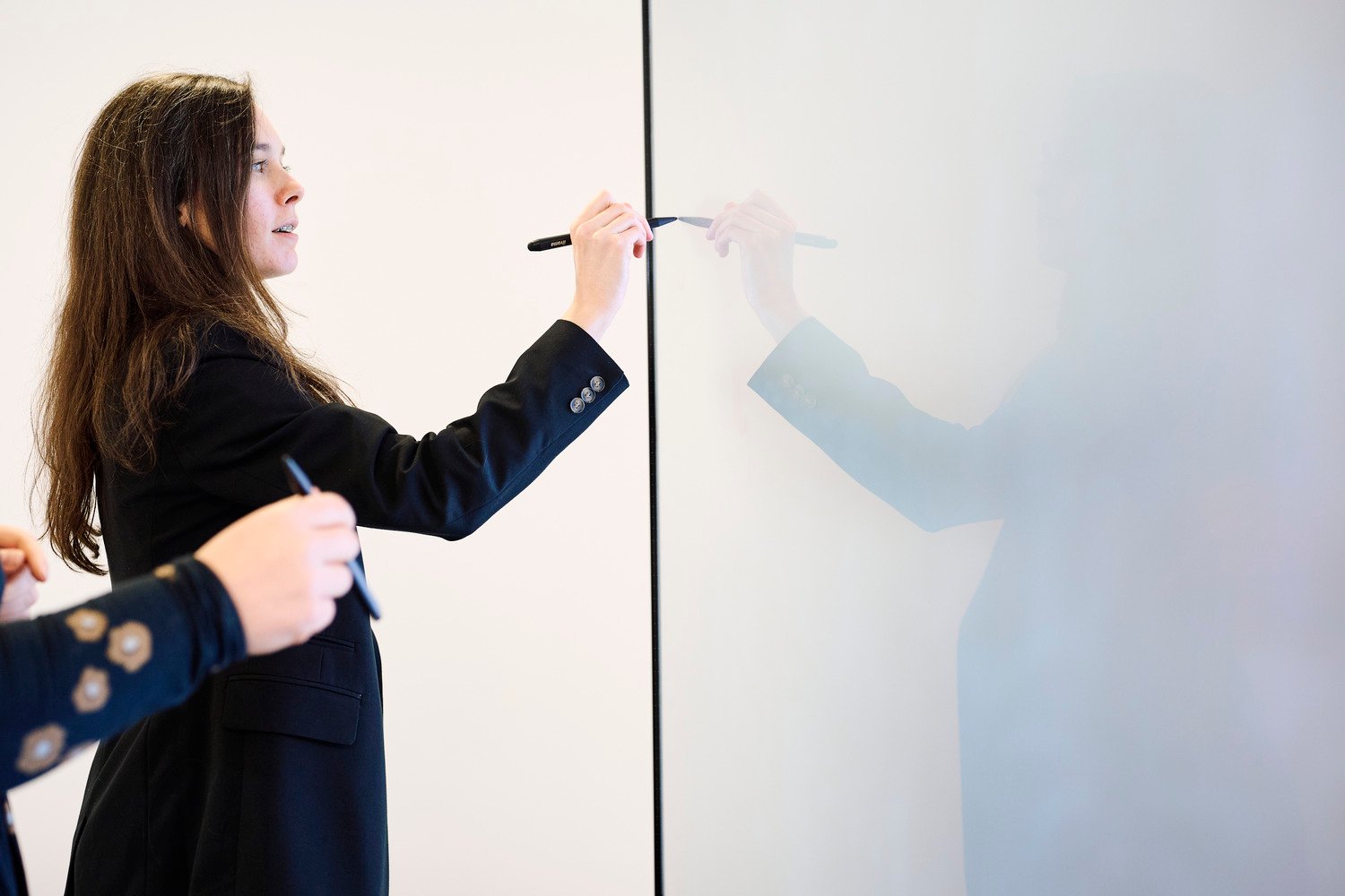 A woman drawing on the interactive display