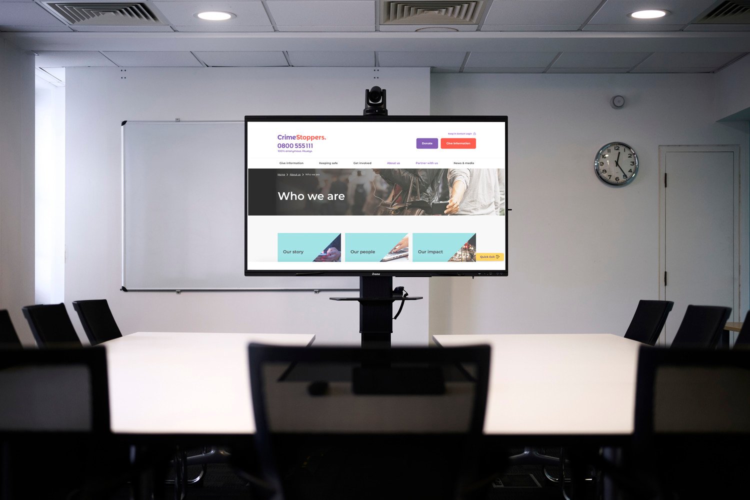 The tv display with tables and chairs placed in front of it.