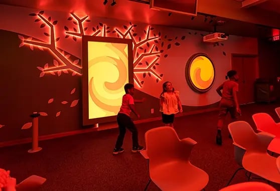 Children playing with the touchscreen and red ambient light at the Byrnes Health Education center