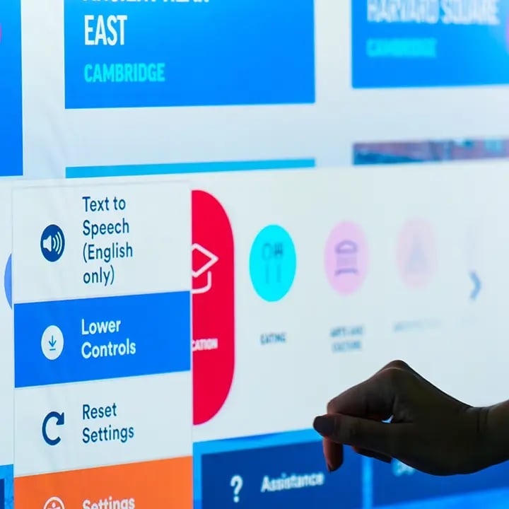A close-up of a hand interacting with a touchscreen interface displaying accessibility settings. Options visible include