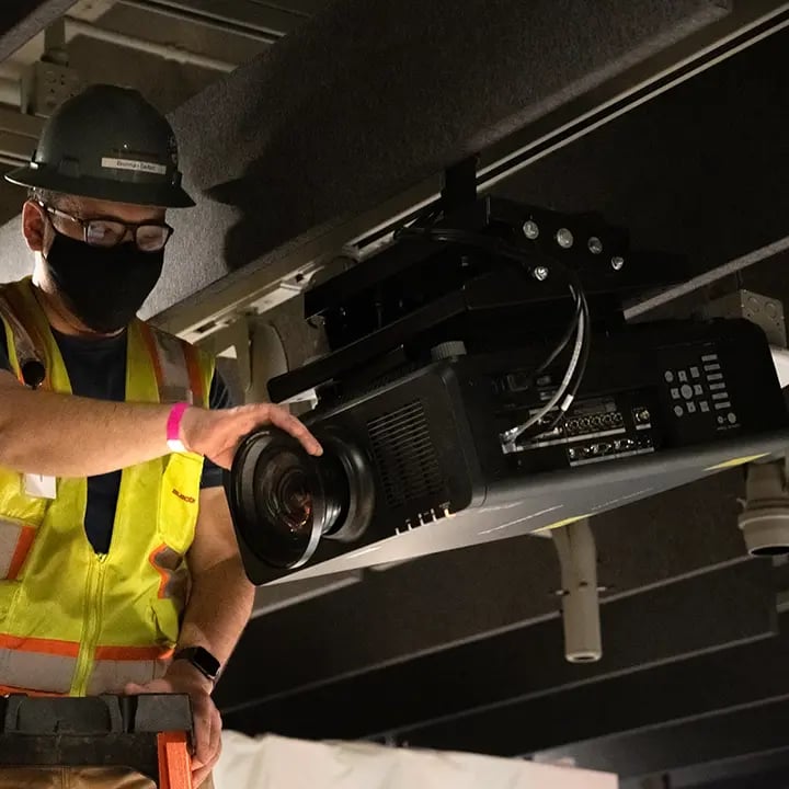 Electrosonic technician installing a projector at a customer site.