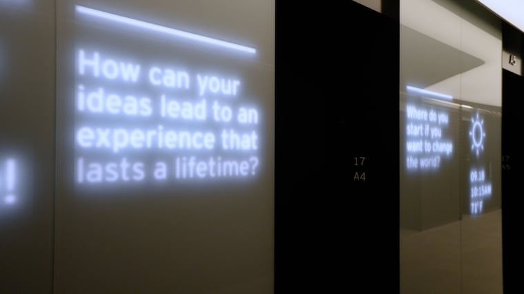 Sleek elevator lobby featuring integrated digital displays, ambient lighting and branded media content designed to enhance the arrival experience.