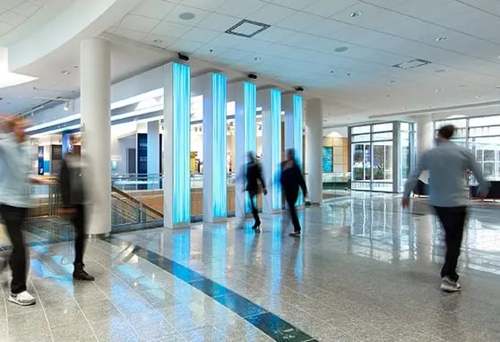 Employees walk past LED columns within the COX Discovery Center