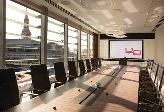 A long conference table equipped with microphones and speakers within Eversheds Sutherland Boardroom.