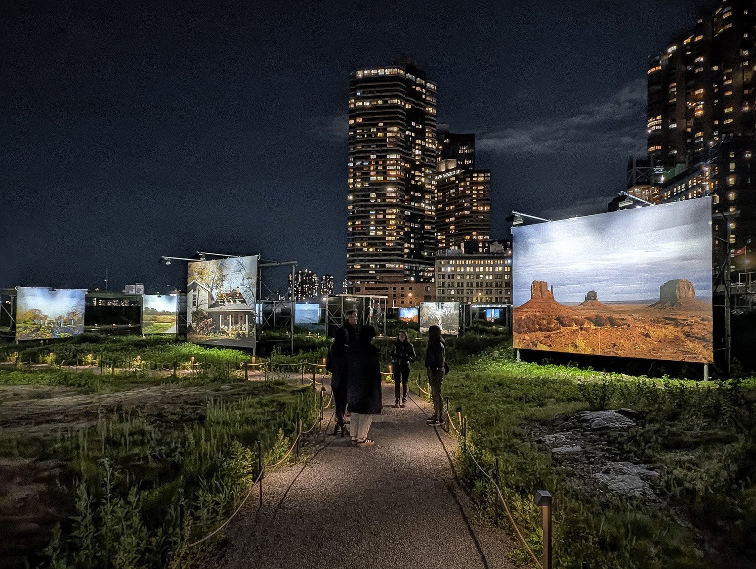A screen display with people walking beside it.