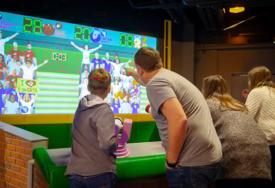 Family visitors play an interactive shooting game at the Mascot Hall of Fame in Whiting, Indiana.