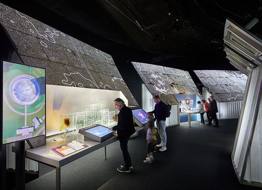 Guests interacting with touchscreens at the First Light Pavilion within Jodrell Bank's visitor centre.