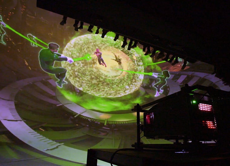 Immersive ride scene showing guests inside a dome theater surrounded by vibrant space visuals, alien worlds and the Green Lantern Corps in action.
