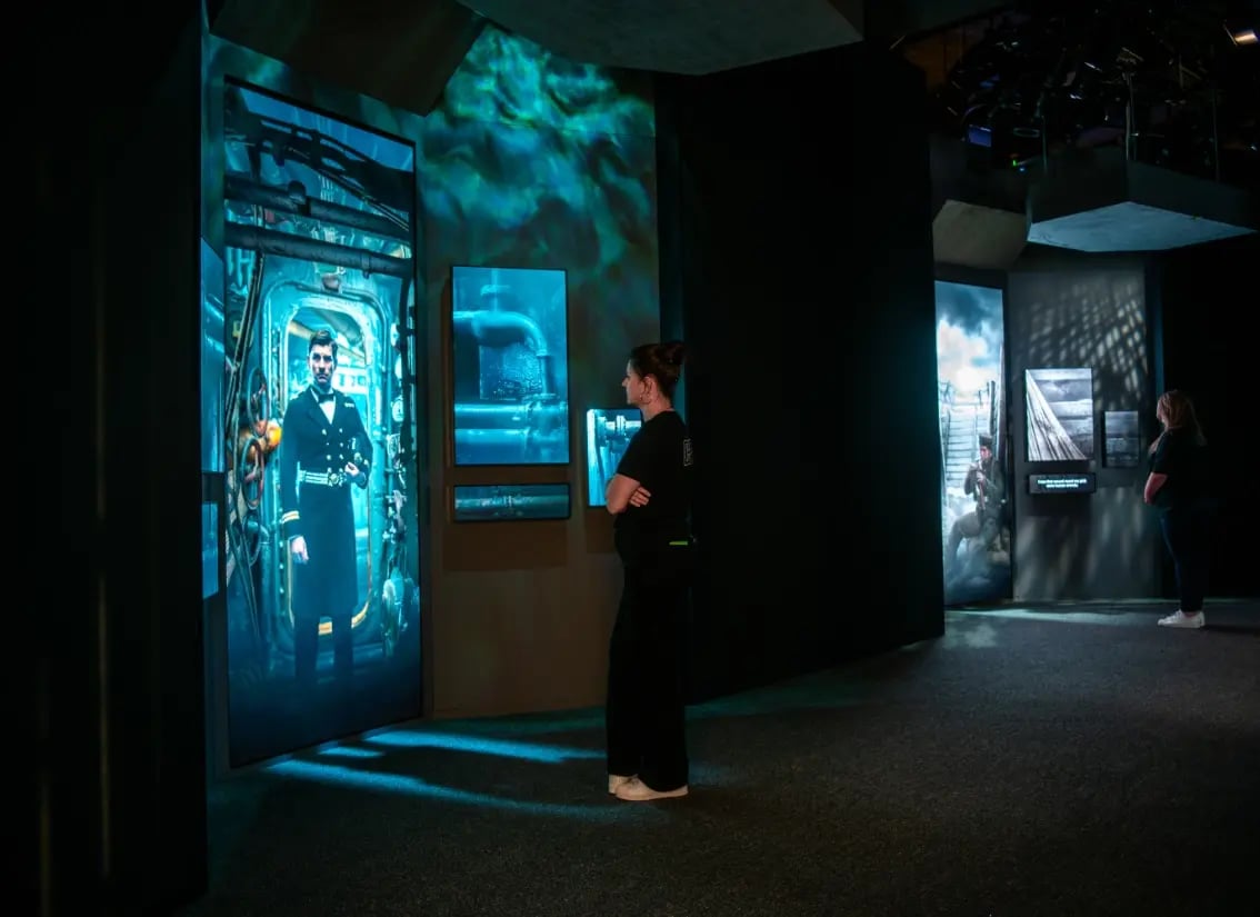 Guests admiring high-tech AV installations within a modern museum space.